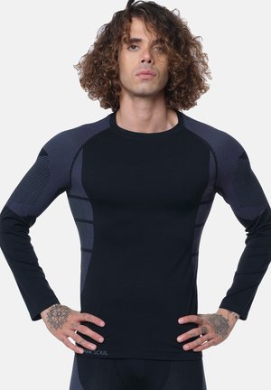 Black long-sleeve athletic shirt with textured mesh accents in shades of gray. Features a fitted design and ribbed neckline.
