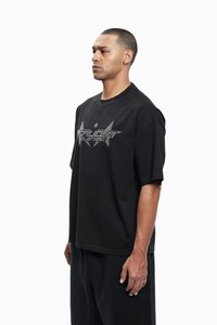 Sort oversized T-shirt lavet af bomuld, med et stort sølv grafisk design med stjerner og tekst foran, korte ærmer og rund hals.