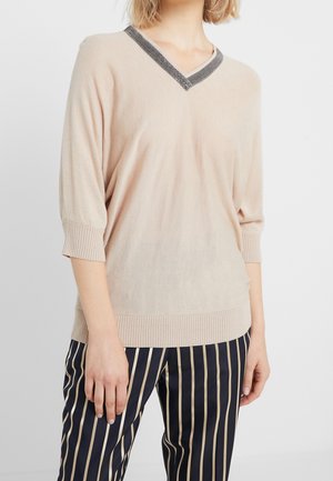 Suéter de punto color beige con escote en V y detalle de cuello oscuro en contraste. Presenta mangas de tres cuartos y un dobladillo acanalado.
