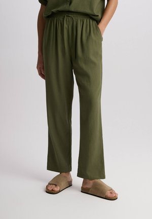 Luźne spodnie w kolorze oliwkowym, wykonane z lekkiego materiału, z elastycznym pasem, bocznymi kieszeniami oraz prostą nogawką.