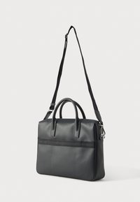 Mala preta em pele com duas alças superiores, correia longa ajustável, bolso frontal com fecho horizontal, textura suave, forma estruturada.