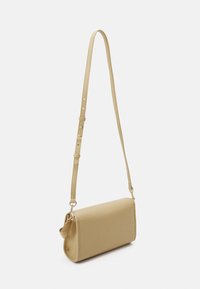 Sac bandoulière rectangulaire beige avec sangle réglable et ferrures métalliques dorées, présenté sur un fond blanc uni.