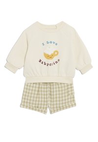 Felpa crema a maniche corte con stampa "I Love Babyccino" e pantaloni corti a quadri verdi con tasche, vita elastica e vestibilità comoda.