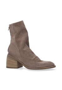 Bottine en daim taupe perforé avec un petit talon carré, bout rond et fermeture éclair sur le côté pour une facilité d'enfilage.