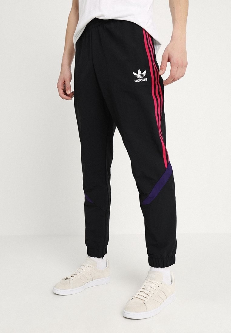 Černé sportovní kalhoty s růžovými a fialovými bočními pruhy, vyrobené z lehkého materiálu, s elastickým pasem a zúženými manžetami.