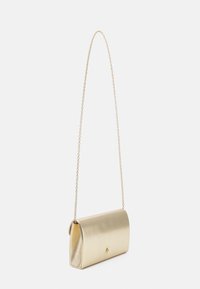 Zlatna metalik clutch torbica cilindričnog oblika, s lancem i malim dekorativnim detaljem sprijeda. Glatka tekstura.