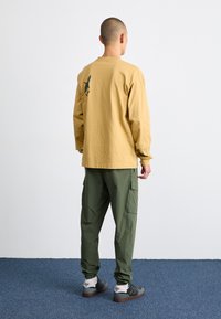 Nike Sportswear SPORTSWEAR CLUB - Reisitaskuhousut - cargo khaki
