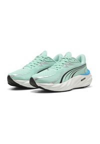 Des chaussures de course bleu clair avec une tige en mesh texturé, des accents réfléchissants, une semelle intermédiaire blanche rembourrée et une semelle extérieure en caoutchouc noir pour l'adhérence.