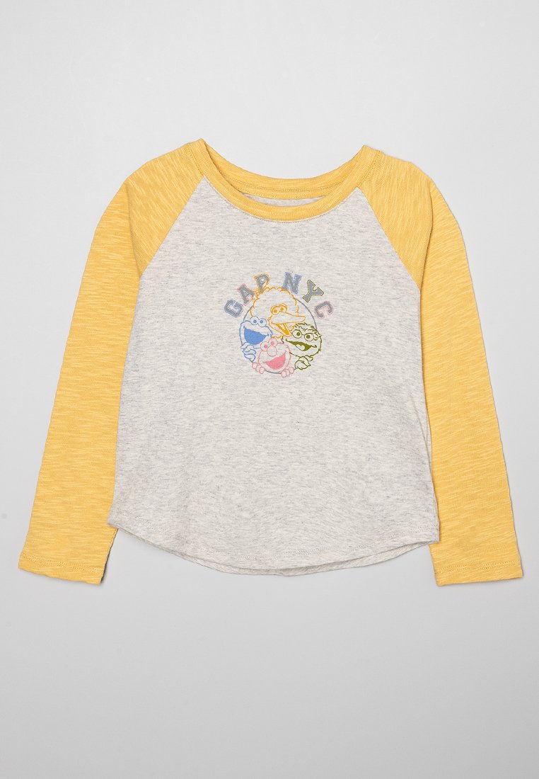 Graues Baumwoll-T-Shirt mit langen Ärmeln und gelben Raglan-Ärmeln, auf der Vorderseite mit einem bunten "GAP NYC"-Logo und Cartoonfiguren bedruckt.