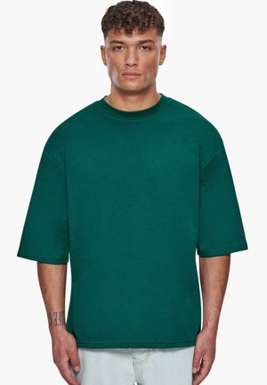 Übergrößes T-Shirt aus Baumwolle in Teal mit Rundhalsausschnitt und kurzen Ärmeln, gerade geschnittenem Saum und minimaler Ausstattung.
