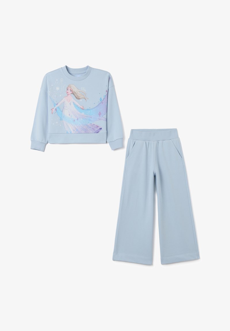 Hellblaues Sweatshirt mit Grafik eines Charakters, kombiniert mit passender weiter Hose. Glattes Material mit elastischem Bund und Taschen.