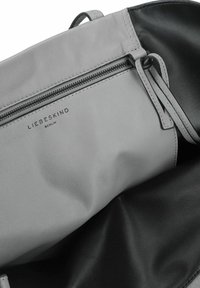 Grijze leren handtas interieur met een zwarte voering, voorzien van een ritszak en het reliëflogo "LIEBESKIND BERLIN". Glad textuur.