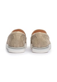 Scarpe slip-on in suede beige con finitura testurizzata, suole in gomma bianca e dettagli di cuciture sul retro, progettate per un abbigliamento informale.