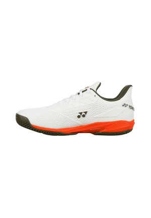 Scarpa sportiva bianca con suola arancione e dettagli neri, taglio basso con lacci, con logo Yonex sul lato e sul tallone.