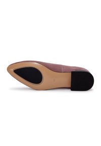 Pantofii din suede roz au vârful ascuțit și toc mic din cauciuc negru. Talpa are o finisare netedă bej cu un insert texturat negru.