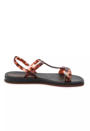 Sandalia negra plana con delgadas correas marrones con estampado carey, incluyendo anilla para el dedo y correa ajustable en el tobillo, sobre fondo blanco.