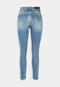 Blå jeans i skinny-modell med hög midja, med två bakfickor och subtila blekningar. Tyget har en slät textur och en klassisk passform.