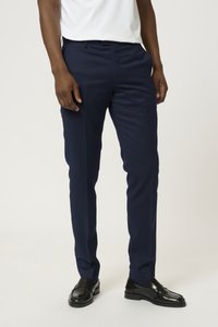 Pantalones de vestir azul marino en corte ajustado, con una textura suave, piernas rectas y un diseño de frente plano, combinados con zapatos negros brillantes.