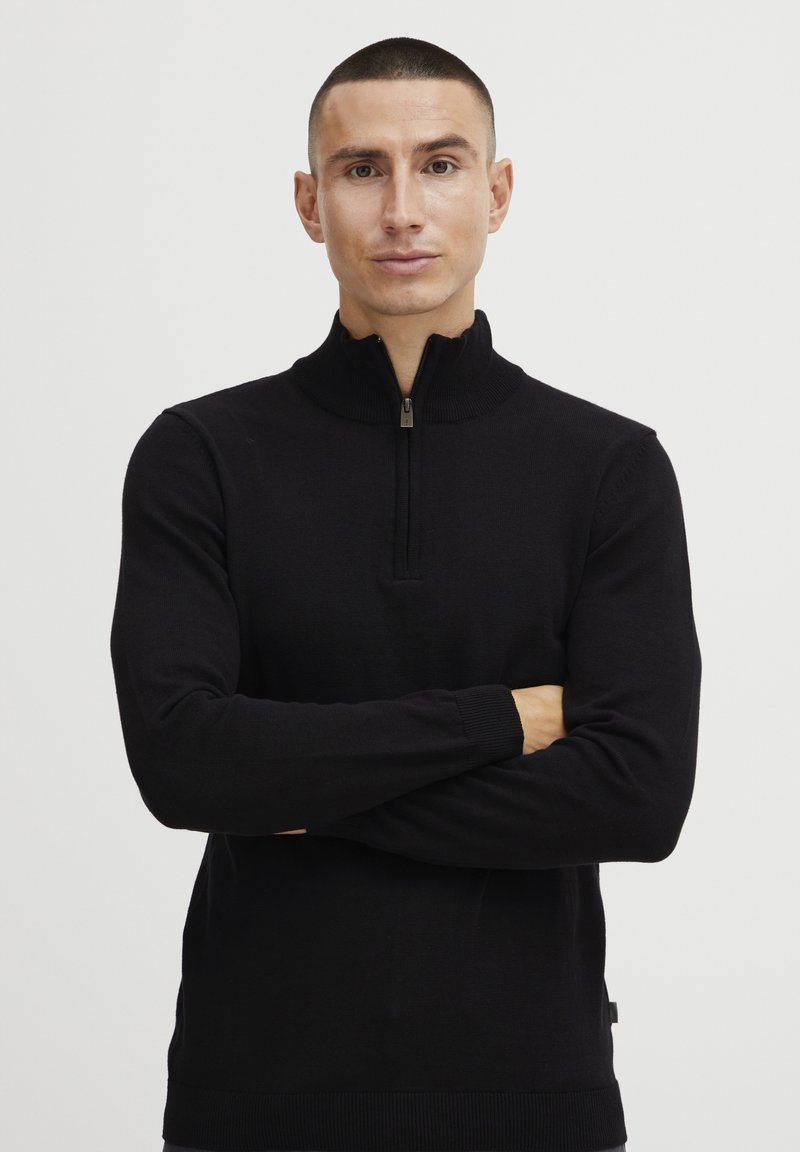 Svart zip-necks genser i en tettsittende design, med ribbestrikkede cuffs og hem, laget av myk strikket stoff, egnet for lagdeling.