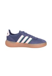 Blue suede and fabric sneaker with beige gum sole, white stripes with green edges, lace-up design, and brand logo on heel tab and tongue.