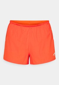 Helles orange Badehose mit strukturierter Oberfläche, elastischem Bund und seitlichen Taschen. Mit einem kleinen weißen Logo auf der unteren rechten Seite.