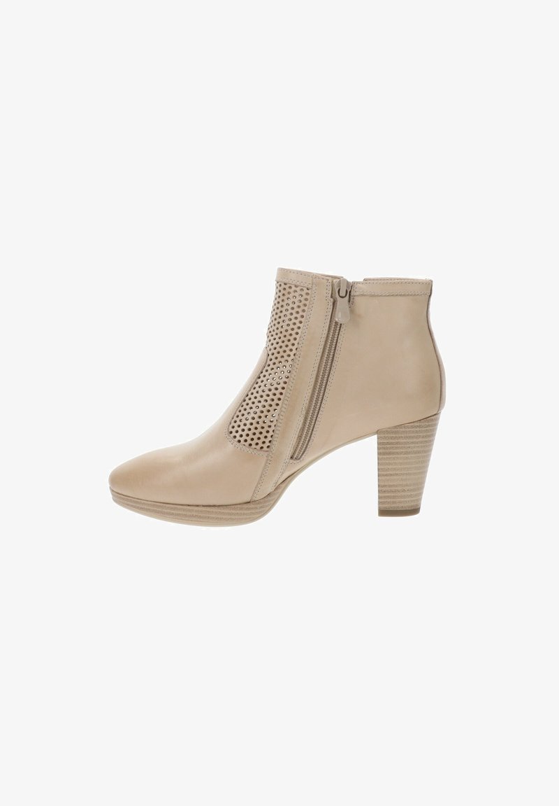 Bottine beige avec un talon empilé de hauteur moyenne, fermeture éclair latérale et panneau perforé sur le côté extérieur pour la ventilation et le style.