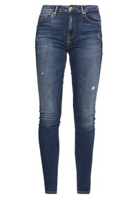 Jeans ajustados en denim azul oscuro con un lavado deslavado, que presentan un sutil desgaste y un diseño clásico de cinco bolsillos con pasadores para cinturón.