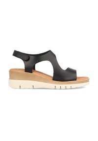 Sandalia cuña de piel negra con lados abiertos, punta redonda, correa ajustable y plantilla marrón; presenta una suela texturizada de color claro.