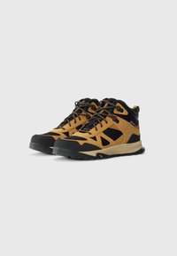Mid-height hiking boots in tan and black with rugged soles and lace-up front, positioned angled left on a white background.