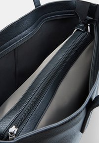 Black leather tote bag with smooth texture. Features multiple zippered compartments and a lined interior. Structured design with sturdy handles.
