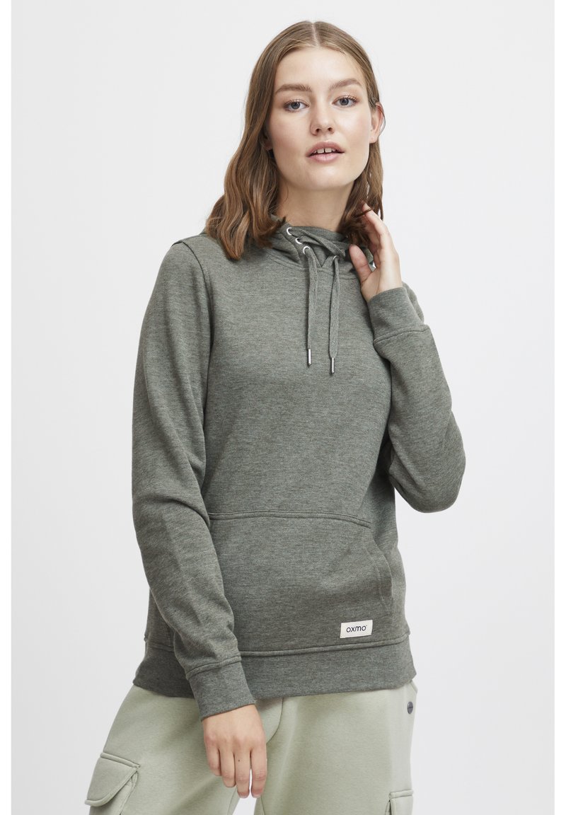 Sudadera con capucha gris hecha de un tejido suave, con un bolsillo canguro, capucha con cordón, puños acanalados y una pequeña etiqueta de logo en el dobladillo.