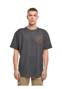 Grå bomulds t-shirt med korte ærmer. Har et hvidt taleboblesgrafik med et rødt knust hjerte-design på brystområdet.