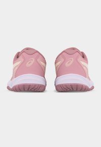 Ζευγάρι ροζ αθλητικά παπούτσια με λευκές σόλες, εμφανιζόμενα από πίσω, δείχνοντας το λογότυπο ASICS και το υφή του πέλματος.