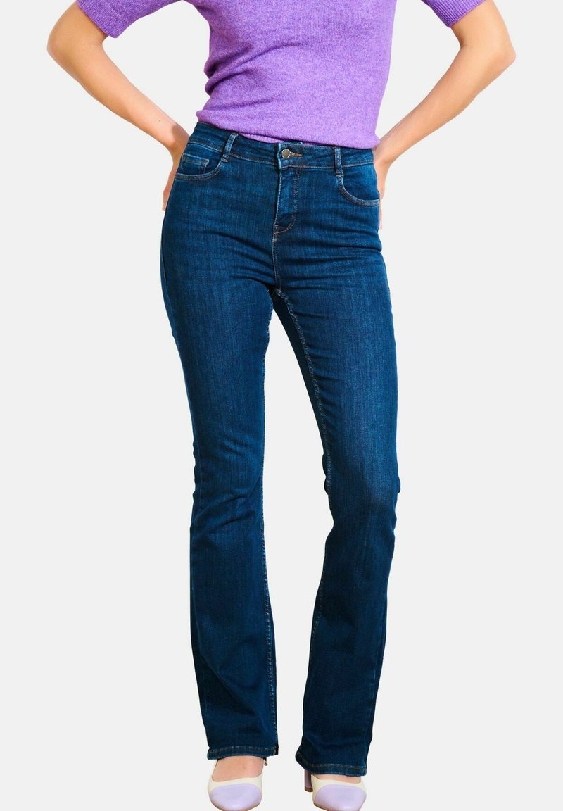 Augstās jostasvietas izpletņu džinsi tumši zilā džinsā; iekļauj piecas kabatas, iezīmētu šuvju un priekšējo poga aizdari. Šaurs griezums augšstilbā.