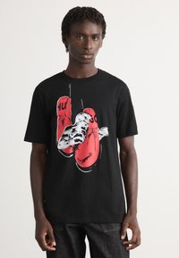 Cămașă t-shirt din bumbac negru, cu un design grafic ce prezintă mănuși de box roșii și un boxer, cu linii de accente albe și guler rotund.