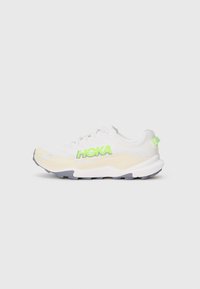Baskets de sport blanches avec un logo "HOKA" vert, dessus texturé, semelle rembourrée et semelle extérieure grise. Lacets et léger rembourrage au niveau du col.