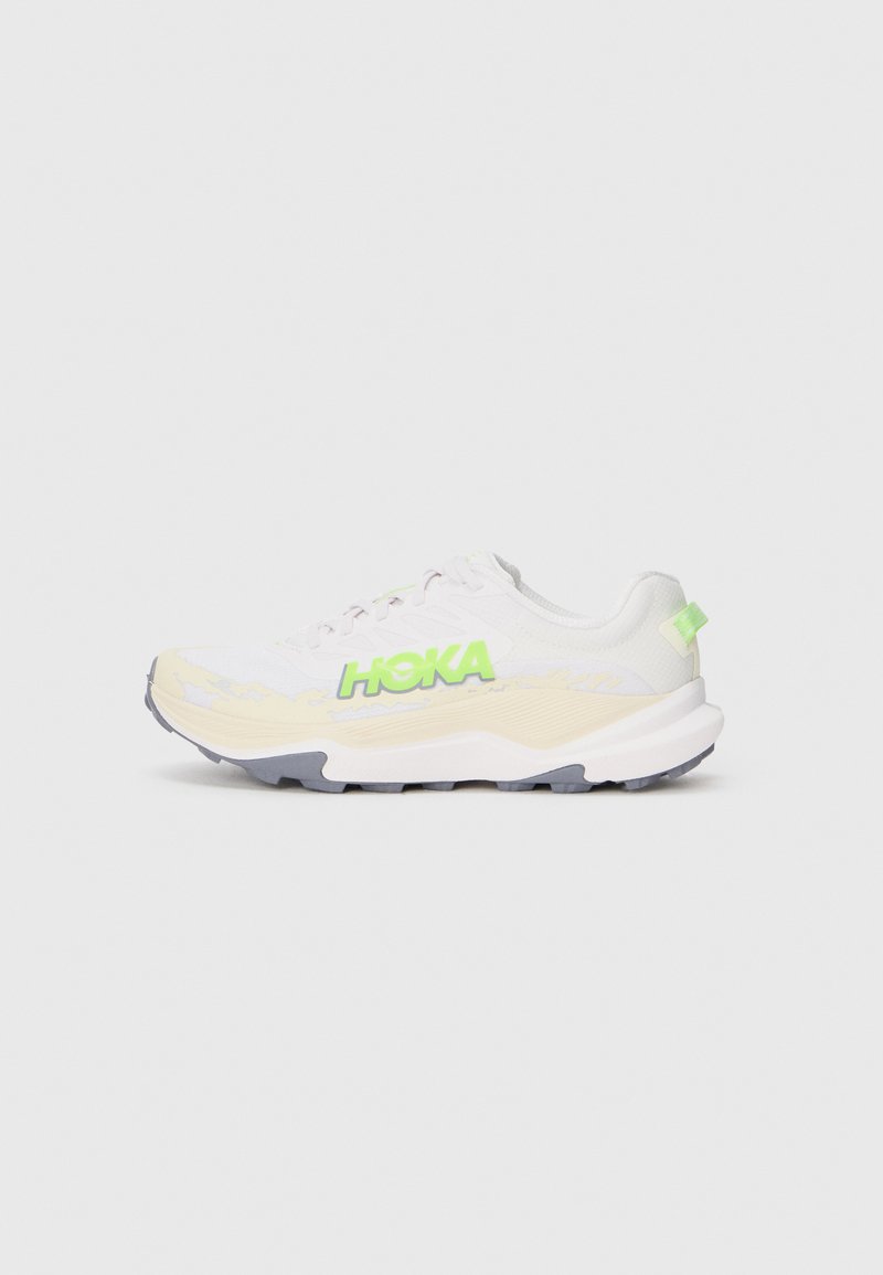 Baskets de sport blanches avec un logo "HOKA" vert, dessus texturé, semelle rembourrée et semelle extérieure grise. Lacets et léger rembourrage au niveau du col.
