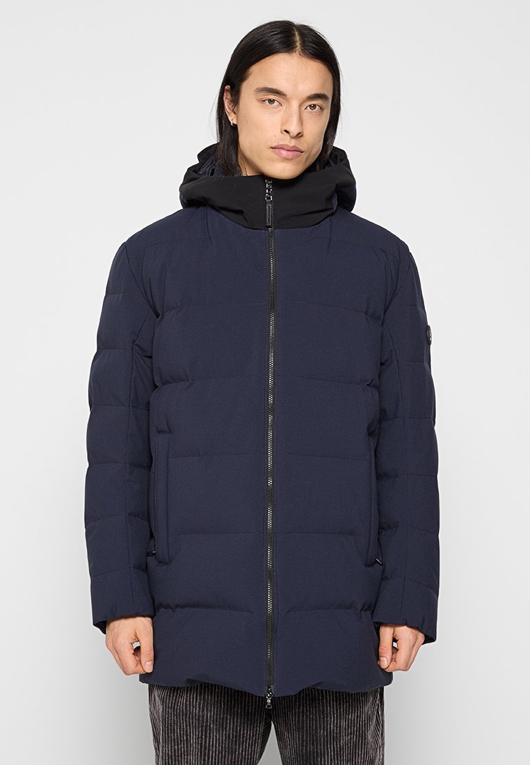 Marineblaue Daunenjacke mit schwarzer Kapuze, vertikal gestepptem Design, durchgehendem Frontreißverschluss und seitlichen Taschen. Glatte Stofftextur.