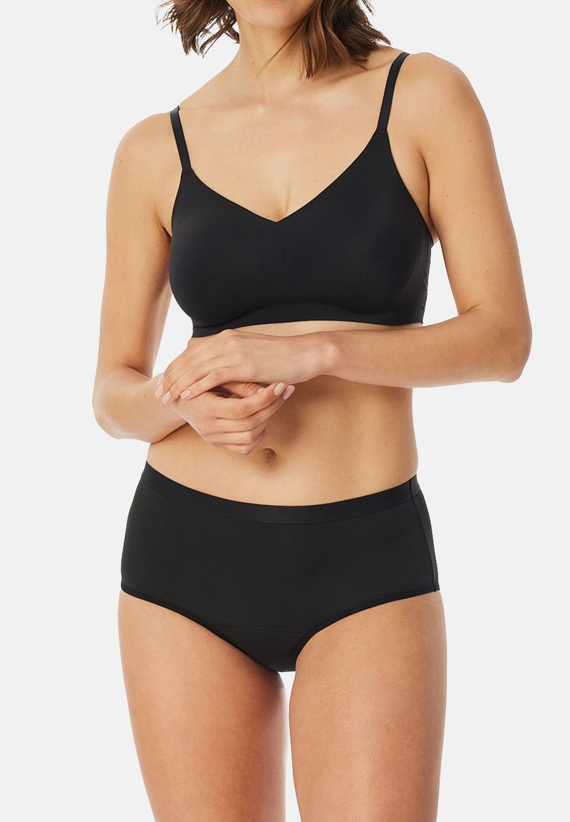 Zwarte draadloze bh met verstelbare bandjes, v-hals ontwerp, gladde stof, gecombineerd met bijpassende zwarte high-waisted slip in vergelijkbaar materiaal.