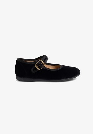 Chaussure plate Mary Jane noire avec un bout rond, texture en velours et une seule sangle à boucle ajustable sur le cou-de-pied.