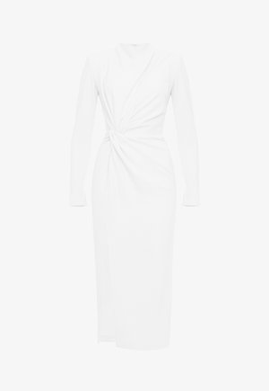 Długa biała sukienka z długimi rękawami, wysokim dekoltem i marszczonym węzłem w talii tworzącym drapowane fałdy.