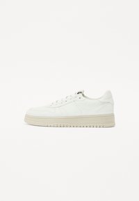 Baskets en cuir blanc avec un bout arrondi, des lacets plats, des rayures latérales subtiles et une épaisse semelle de couleur crème avec un motif de texture.