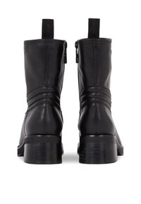 Stivaletti neri in pelle con finitura liscia, pannelli laterali elasticizzati, cuciture a contrasto e un robusto tacco a blocco per un supporto ottimale.