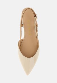 Beige lakkbőr, hegyes orrú, pántos cipő nude színű gumitalppal. Állítható aranyszínű csatos pánttal rendelkezik. Simább textúrájú.