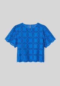 Blouse bleue en eyelet avec des manches courtes, un ourlet festonné et un motif découpé circulaire. Dispose d'une fermeture à bouton dans le dos en forme de trou de serrure.