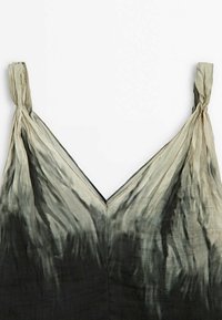 Robe sans manches avec fines bretelles et un décolleté en V, présentant un dégradé allant du gris clair en haut au gris foncé en bas.