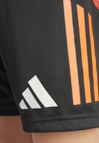 Schwarze Sportshorts mit orangefarbenen vertikalen Streifen und einem weißen Logo mit drei diagonalen Streifen am Saum. Glattes, leichtes Material.