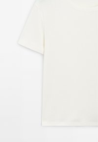 T-shirt a maniche corte in cotone color crema, con scollatura rotonda e texture liscia, con taglio dritto all'orlo.