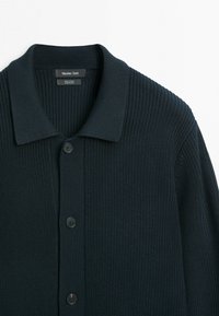 Donker marineblauwe gebreide katoenen cardigan met kraag en drie zwarte knopen aan de voorkant, gelabeld Massimo Dutti, gemaakt in China.
