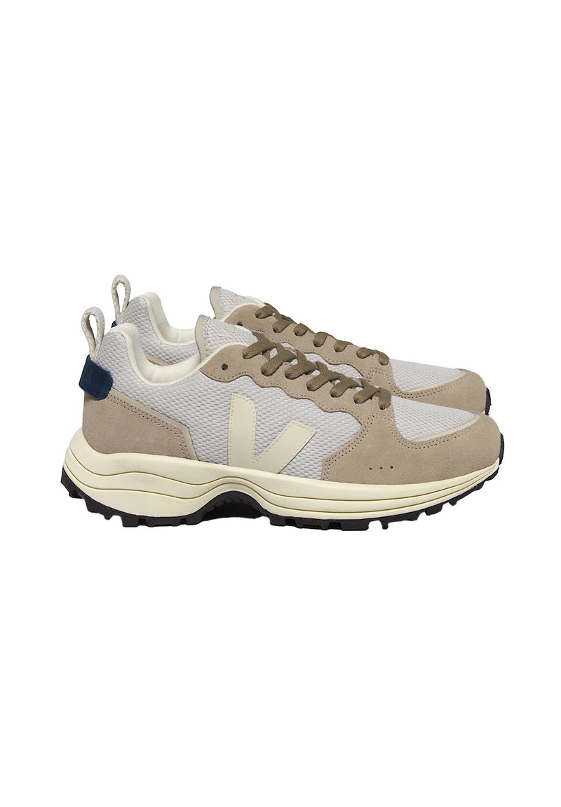 Beige and grey sneaker made of mesh and suede, featuring a rubber sole, rounded shape, and a contrasting blue heel tab.